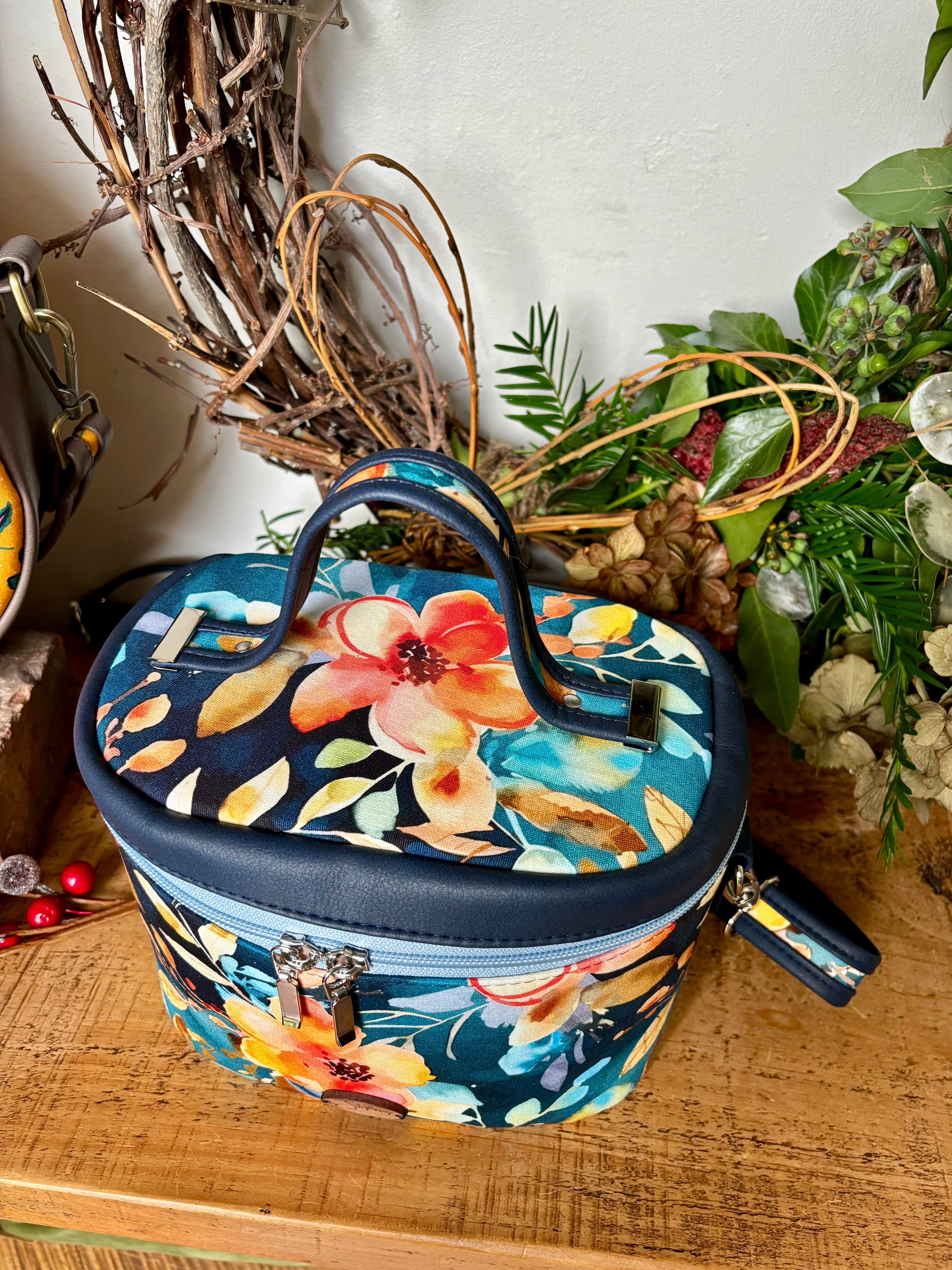 Exquisite Bellini Blossoms Teresita Train Case, a stylish and practical accessory for your beauty essentials, featuring a floral design in vibrant hues and nickel silver hardware.